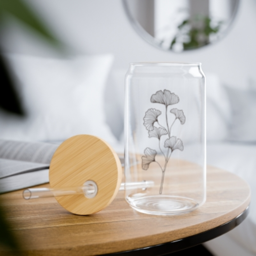 Image of glass drinking glass with wooden lid and glass straw sitting on a table to see a real image of it.